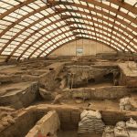 Overkapte archeologische opgraving met oude muurresten
