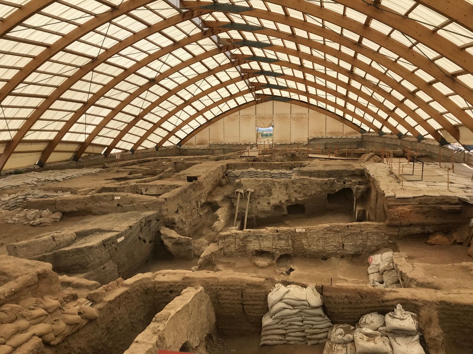 Overkapte archeologische opgraving met oude muurresten
