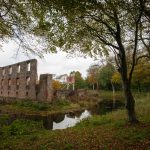 Ruïne die weerspiegelt in een bosvijver in de herfst